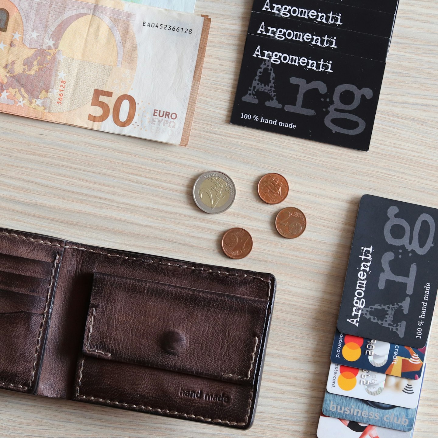 Monedas de cartera y tarjetas de crédito dispuestas sobre una superficie de madera.