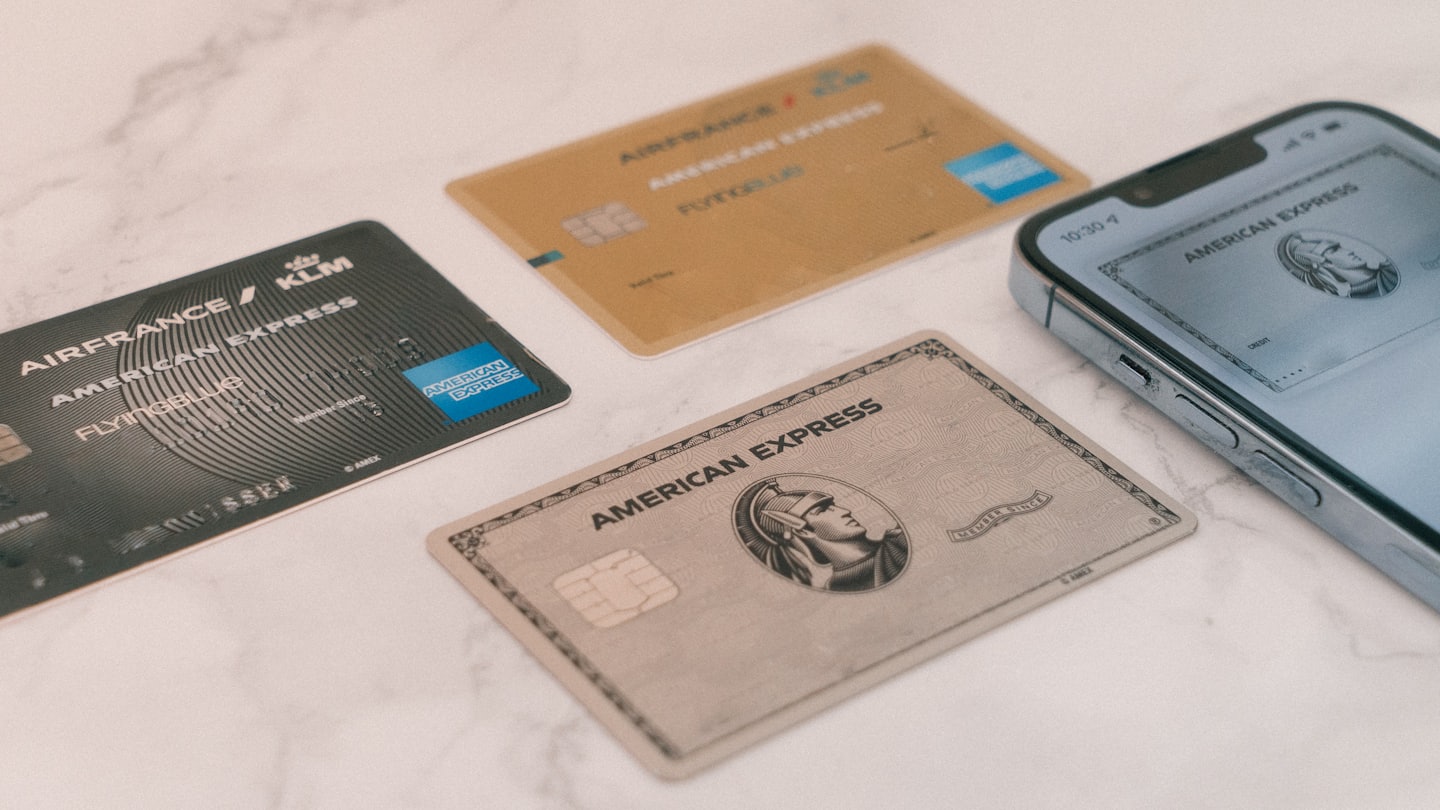 Tarjetas de crédito y smartphone con tarjeta digital sobre mármol.